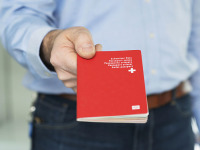 Bild: Ein Mann zeigt den Schweizer Pass. Quelle: Keystone/Christian Beutler